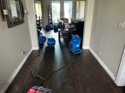 Air movers drying a wet hardwood hallway after a water leak in Weatherford