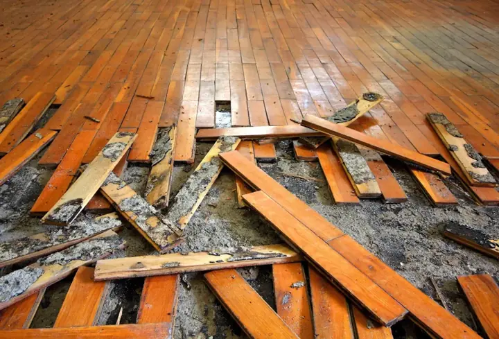 Water-damaged hardwood boards pulled up from a soaked subfloor