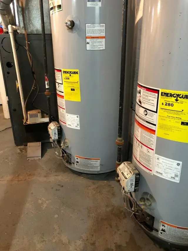 Water pooling on a concrete floor under failed tank water heaters